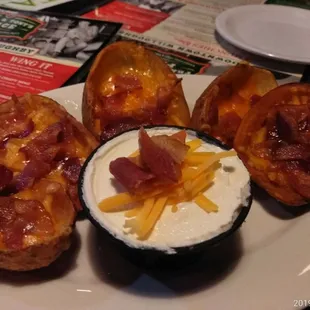 a plate of baked potatoes with cheese and bacon