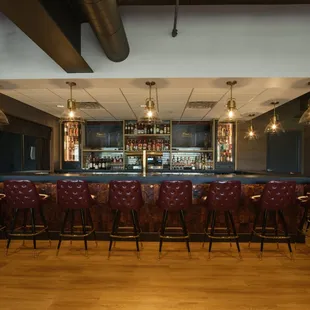 a bar with red leather chairs