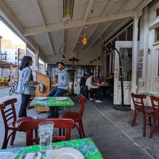 a group of people sitting at tables outside of a restaurant