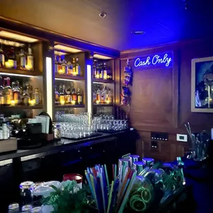 a dimly lit bar with bottles and glasses
