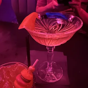a man sitting at a table with a drink and a cell phone