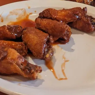 Chicken wings in Frank&apos;s hot sauce. The plate had a few more wings and a side of celery.