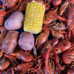 a plate of craws, potatoes, and corn