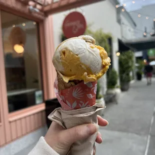 a hand holding a cone of ice cream