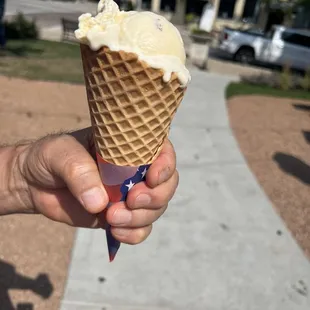 a hand holding an ice cream cone