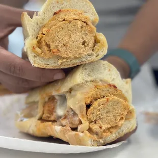 a person holding a sandwich