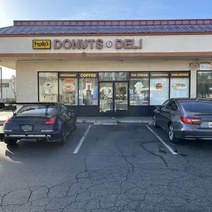 two cars parked in front of a donut shop