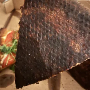 a hand holding a piece of pizza