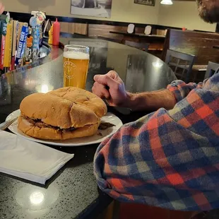 a man sitting at a bar with a sandwich