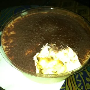 Delicious tiramisu (round bowl ~4in in diameter?)!! The lighting is dim to prob set the mood...