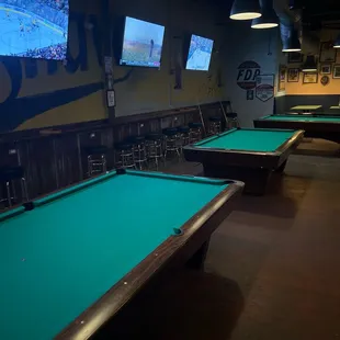 a row of pool tables in a sports bar