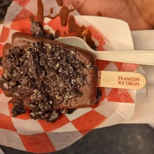 a hand holding a piece of cake