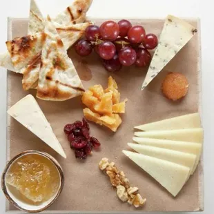 a platter of cheese, crackers, and fruit