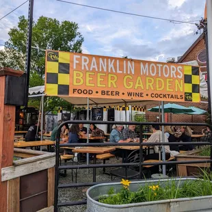 Outside. Storefront sign for Franklin Motors Beer Garden at corner of W Franklin St and S Graham St.