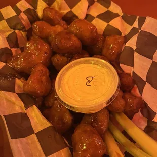 a basket of chicken wings with dipping sauce