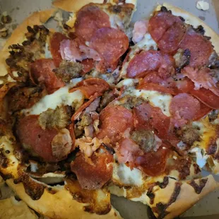 Meat pizza, crust is broken apart.