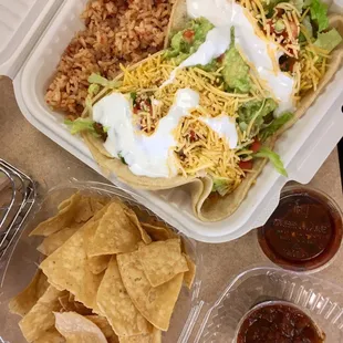 Carnitas and chicken tacos with rice and chips.