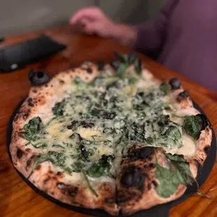  a pizza with spinach and cheese