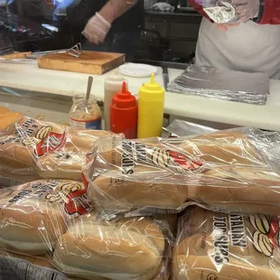 a man putting ketchup on buns