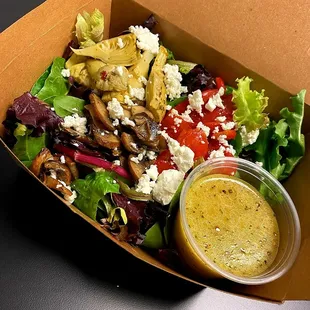a salad in a box with dressing