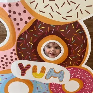  young child peeking out of a donut hole