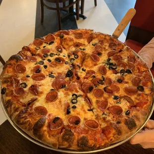 Delicious pepperoni and  black olive pie