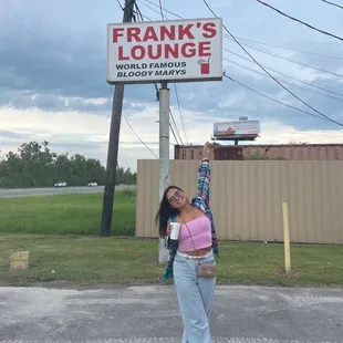 a woman standing in front of a sign