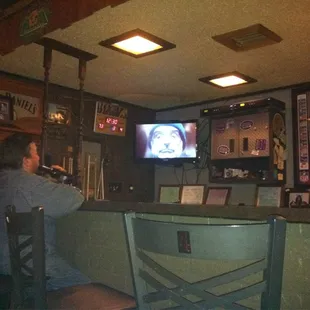 a man sitting at a bar watching tv