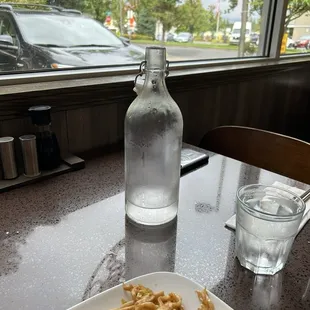 The server brings a cold bottle of water to every table.