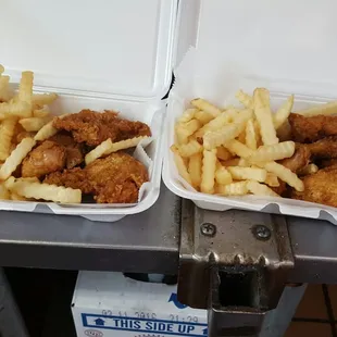 two trays of fried chicken and french fries