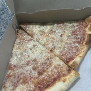 a slice of cheese pizza in a box