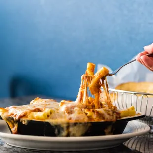 a person taking a bite out of a piece of pizza