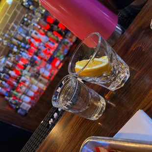 two shot glasses of water and a slice of lemon