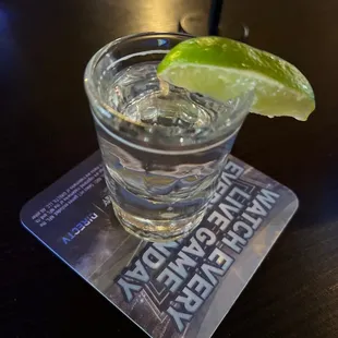 a shot of water with a lime wedge