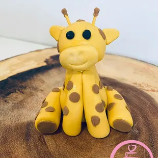 a giraffe sitting on a piece of wood