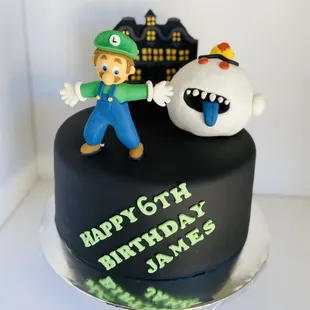 Luigi's mansion cake, wrapped in fondant with edible figures made out of gum paste on top.