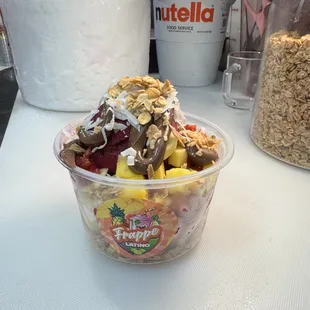 This is our açaí bowl top off with , Nutella,  granola, shredded coconut , strawberry&amp; mangos