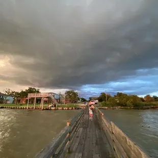 people walking on a bridge over a river