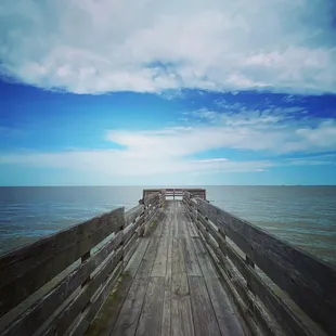 a pier with a bench overlooking the ocean