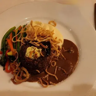 Beef Tenderloin filet mignon with mashed potatoes, mushroom gravy, and vegetable spears and fried onions.