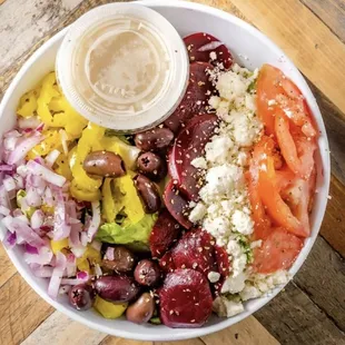 Greek Salad: Mixed greens, onion, mild peppers, Kalamata olives, feta cheese, beets, tomatoes and Greek dressing.