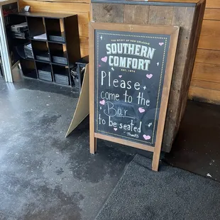 When you enter, you walk around a wall to find the bar.