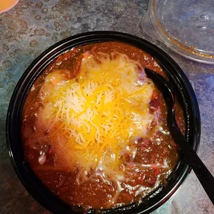a bowl of chili and cheese