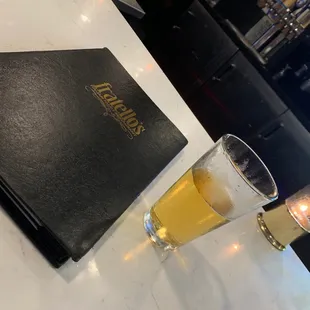 a glass of beer and a menu