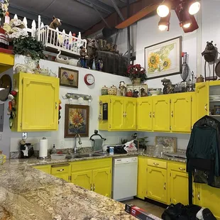 Bright yellow kitchen cabinets and antiques up above