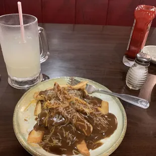 Hamburger patty topped with steak fries, gravy, and cheese