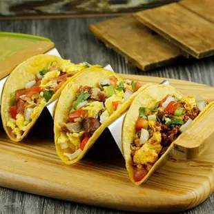 three tacos on a cutting board