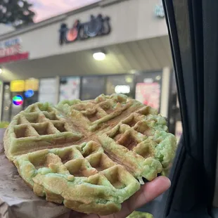 a person holding a waffle in their hand