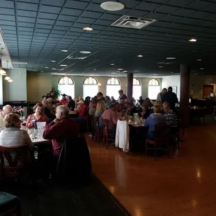 a large group of people sitting at tables in a restaurant