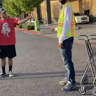 a man with a shopping cart in front of a store